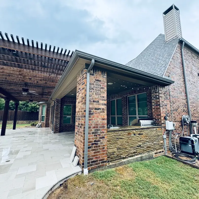 Covered patio beside a brick house