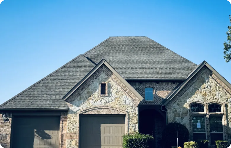 Stone and brick house with a multi-gabled shingle roof
